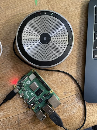 a Pi 4 attached to a senheiser speaker mic on a wooden background